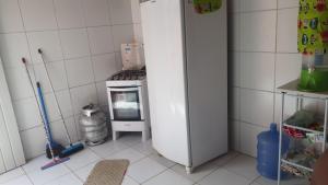 a kitchen with a stove and a white refrigerator at Casa em Itamaracá no Pilar, próximo da praia in Itamaracá