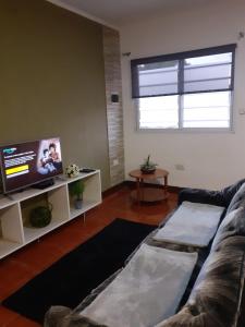uma sala de estar com um sofá e uma televisão de ecrã plano em DEPARTAMENT AMATT (15 min del Aeropuerto Internacional Ezeiza) em Monte Grande