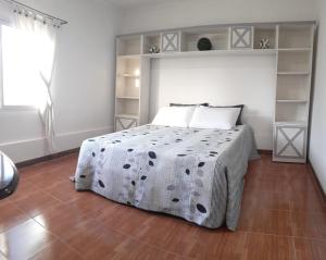 a bedroom with a bed with a black and white blanket at DEPARTAMENT AMATT (15 min del Aeropuerto Internacional Ezeiza) in Monte Grande