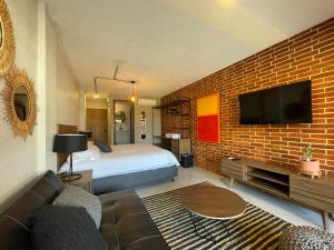 Habitación de hotel con cama y pared de ladrillo en Estacion Alameda Downtown, en Orizaba
