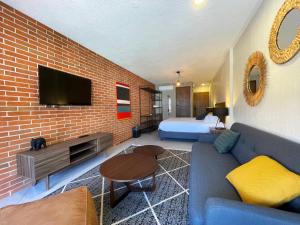 a living room with a couch and a bed and a tv at Estacion Alameda Downtown in Orizaba