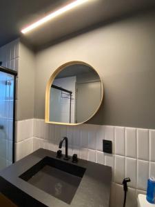 une salle de bain avec un lavabo et un miroir dans l'établissement 97 New studio next Paulista Av, fast wifi and balcony, à São Paulo 16 autres photos