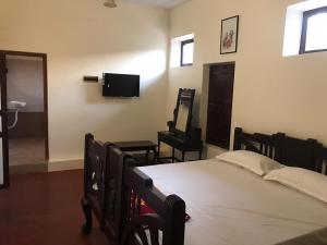 una camera con letto e TV a schermo piatto di TANJORE INN a Thanjāvūr