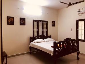 坦贾武尔TANJORE INN的带床和吊扇的卧室