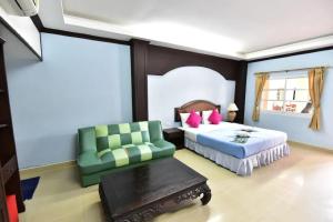 a bedroom with two beds and a green chair at Ampan Resort & Apartment in Nong Prue +36 photos