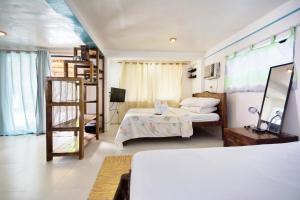 Un dormitorio con una cama y una escalera en una habitación en Niu Ohana East Bay Apartments, en Boracay