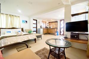 Sala de estar con cama y mesa en Niu Ohana East Bay Apartments, en Boracay