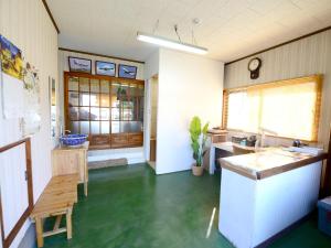 um quarto com uma cozinha com piso verde em Haruno Guesthouse em Tosa