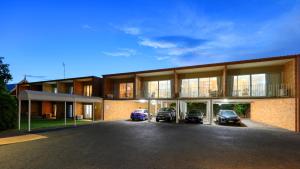 a large building with cars parked in front of it at Court Street Motel in Parkes