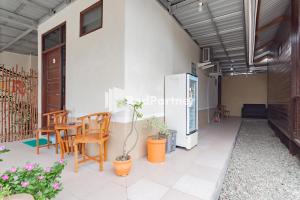um quarto com um pátio com cadeiras e uma mesa em Langkar Guest House Syariah Mitra RedDoorz em Samarinda