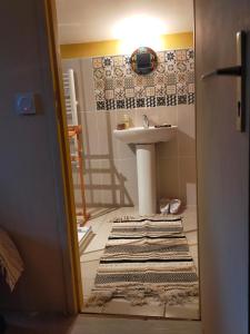 a bathroom with a sink and a rug on the floor at Daphrose chambre in Lachau
