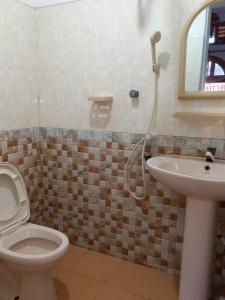 a bathroom with a toilet and a sink at Villa Luxez in Kalmunaikudiyiruppu +28 photos