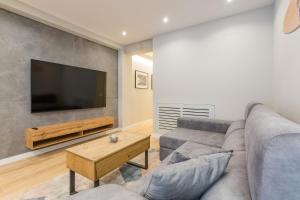 a living room with a couch and a flat screen tv at Apartamento de Lujo en Logroño Centro in Logroño