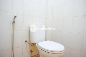 a bathroom with a white toilet and a shower at Pringgondani Guest House At Pandanaran Hills Semarang in Semarang