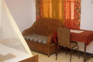 einen Tisch, einen Stuhl, einen Tisch, einen Tisch und einen Tisch in der Unterkunft Remarkable 10-Bed Cottages in Bagamoyo in Bunju