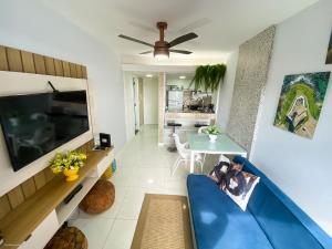 a living room with a blue couch and a television at Ondina Apart Hotel Salvador in Salvador