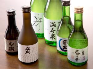 un grupo de cuatro botellas de vino en una mesa en Tateyama Kurobe Alpine Route Senjuso 立山黒部アルペンルート千寿荘, en Tateyama