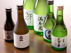 un gruppo di quattro bottiglie di vino su un tavolo di Tateyama Kurobe Alpine Route Senjuso 立山黒部アルペンルート千寿荘 a Tateyama