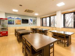 una sala da pranzo con tavoli, sedie e finestre di Tateyama Kurobe Alpine Route Senjuso 立山黒部アルペンルート千寿荘 a Tateyama