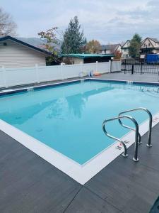 a large swimming pool with blue water in a yard at Top Floor on Okanagan Lake with AC & Heated Pool in Vernon