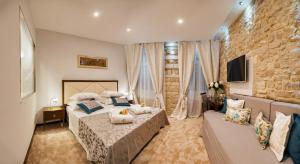 a hotel room with a bed, table and chairs at Heritage Hotel Antique Split in Split