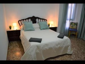 a bedroom with a large white bed with two lamps at 1 bedroom Apartment with Gallery Balcony Free Netflix, air conditioning in Alicante