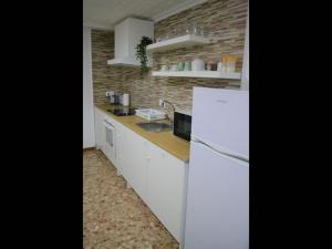 kuchnia z białymi urządzeniami i ceglaną ścianą w obiekcie 1 bedroom Apartment with Gallery Balcony Free Netflix, air conditioning w Alicante