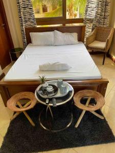 a bedroom with a bed with a table and two chairs at SeaOne Nyali Mombasa Private Studio w/ pool in Mombasa