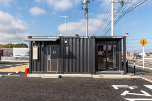 a black building on the side of a street at HOTEL R9 The Yard Nakatsu in Nakatsu