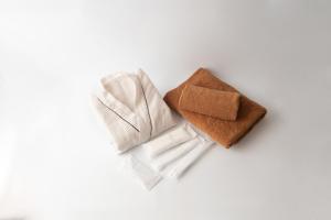 a pile of towels on a white background at HOTEL R9 The Yard Nakatsu in Nakatsu