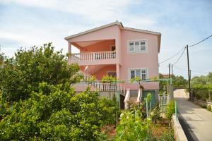 Casa de color rosa con balcón en Apartments Bosotina en Kukljica