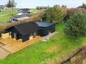 een zwart huis op een groen veld bij 10 person holiday home in Vinderup in Vinderup