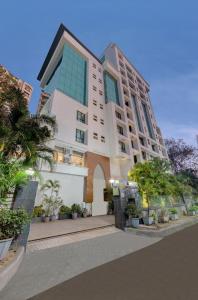 a large building with trees in front of it at Click Hotel Caliph, Mumbai in Mumbai