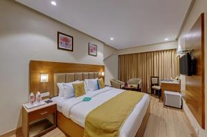 a hotel room with a large bed and a desk at Click Hotel Caliph, Mumbai in Mumbai