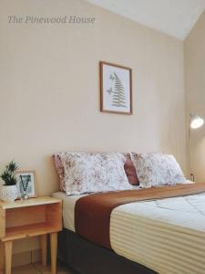 CinengangirangThe Pinewood House Villa Kota Bunga by Citrus House的一间卧室配有一张床,床头柜位于bedenalsenalsenalsenal旁边。