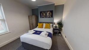 a bedroom with two beds with yellow and blue at Station House By Horizons Stays in Darlington