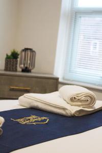 a pile of towels sitting on top of a bed at Station House By Horizons Stays in Darlington