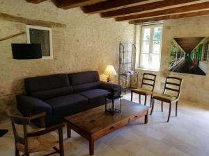 ein Wohnzimmer mit einem Sofa, Stühlen und einem Tisch in der Unterkunft Gîte Ainay-le-Vieil, 5 pièces, 8 personnes - FR-1-586-15 in Ainay-le-Vieil