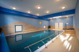 a large swimming pool in a building with a swimming pool at LD PALACE II Spa & Kur in Františkovy Lázně