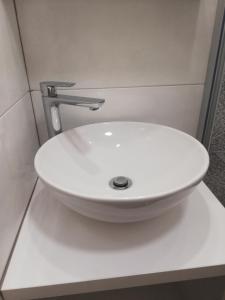 a white bathroom sink with a silver faucet at Sobe Šušanj in Karlobag