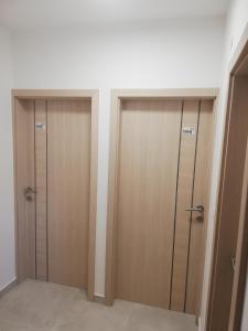 two wooden doors in a room with a wall at Sobe Šušanj in Karlobag