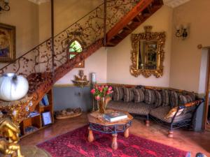 a living room with a couch and a staircase at Castle in Clarens in Clarens