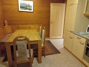 a kitchen with a wooden table and a table and chairs at Chalet Adler in Grächen