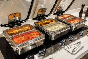 a buffet with several trays of food on a counter at Марциаль in Tyumen