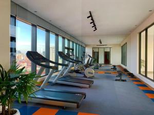 un gimnasio con filas de cintas de correr y máquinas elípticas en K Residence & Apartment, en Phnom Penh