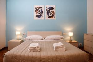 a bedroom with a large bed with towels on it at Etruria Airport in Pisa