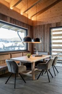 - une salle à manger avec une table et des chaises en bois dans l'établissement ALM CHALET, à Annaberg-Lungötz