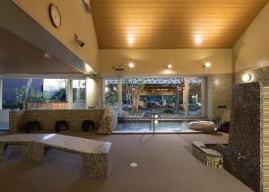 a lobby with a bench and a clock on the ceiling at Manten no Yu Michi no Yado in Nonoichi