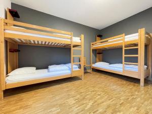 two bunk beds in a room with wooden floors at Geneva Hostel in Geneva