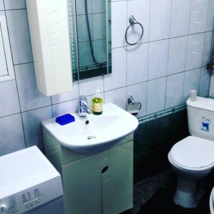 a bathroom with a white sink and a toilet at Квартира 5-9 in Aktau